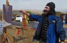 Alexey shouts, "We should wear wet suits to paint in this weather!"